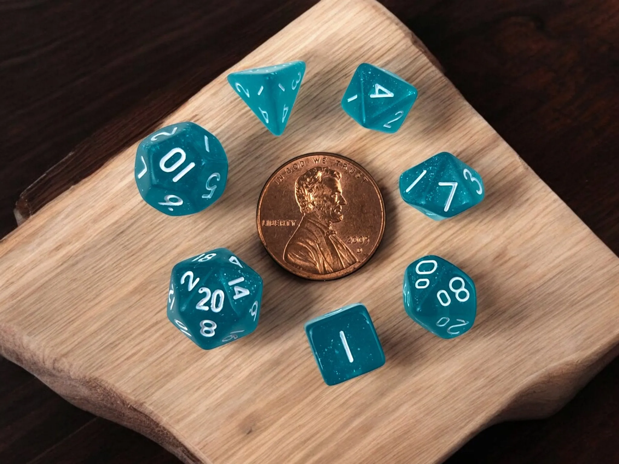Mini drawstring bag with a set of mini dice, light teal with some glimmer.